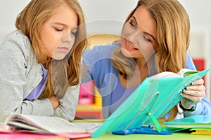 Portrait of a beautiful little cute girl reading book