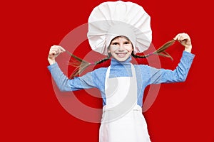 Portrait of beautiful little girl in form of cook on red. Kid chef. Cooking Concept