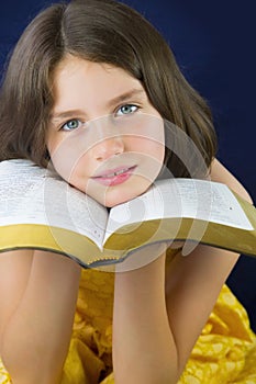 Portrait of beautiful little girl holding Holy Bible