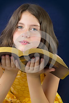 Portrait of beautiful little girl holding Holy Bible