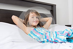 Portrait of beautiful little girl lying on bed photo
