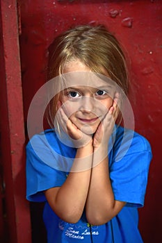 Portrait of beautiful little girl on red wall background.