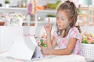 Portrait of beautiful little girl with tablet pc