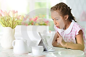 Portrait of beautiful little girl with tablet pc has an idea