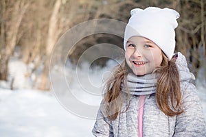 Portrait of a beautiful little girl in winter park