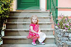 Portrait of beautiful little gorgeus lovely toddler girl in pink summer look clothes, fashion dress, knee socks and hat