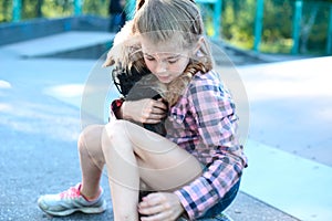 Portrait of a beautiful little teenage girl, hugging a small dog