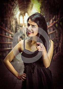 Portrait of a beautiful and lonely girl suffering of anorexy, wearing a black dress and pointing in front oh her using