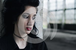 Portrait of beautiful lonely sad goth girl outdoor in autumn