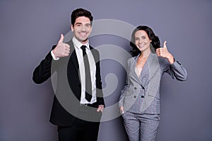 Portrait of beautiful man and woman business people having brunet wavy curly hairstyle showing thumb up wearing black