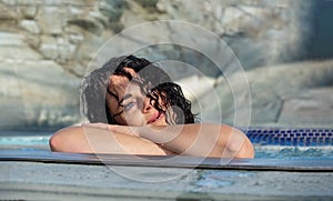 Portrait of beautiful mature woman with dark curly hair relaxes contend happy in holidays summer sun in the spa wellness whirlpool photo