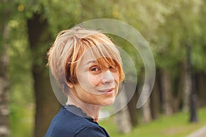 Portrait of beautiful mature woman with elegant red short haircut outdoors