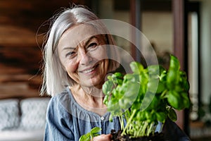 Portrait of beautiful mature woman taking care of plants on balcony. Spending free weekend at home.