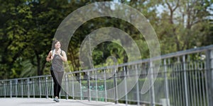 Portrait of beautiful middle-aged Asian women wearing sportswear Holding a towel Walk in park With a happy