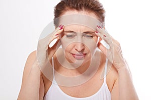 Portrait of beautiful middle aged brunette woman with headache on white. Migraine, menopause and stress. Copy space and m