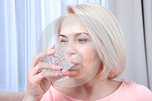 Portrait beautiful middle aged woman drinking water in the morning