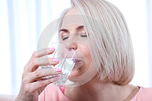 Portrait beautiful middle aged woman drinking water in the morning