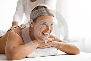 Portrait Of Beautiful Middle Aged Woman Having Back Massage In Spa Salon