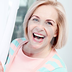 Portrait beautiful middle aged woman smiling friendly and looking into the camera. Woman's face close up