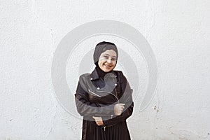 Portrait of beautiful middle-eastern girl in traditional Islamic clothing - hijab. Modern and young Iranian woman in leather photo