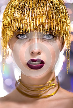 Portrait of a beautiful model with creative make-up and  golden jewelery from paper clips