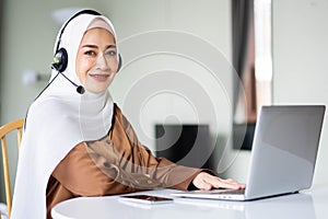 Portrait of beautiful Muslim women wearing hijab customer support phone operator at workplace. Professional operator concept