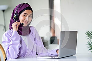 Portrait of beautiful Muslim women wearing hijab customer support phone operator at workplace. Professional operator concept