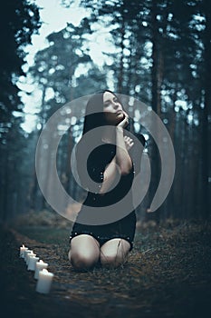 Portrait of a beautiful mysterious woman in the forest. Cold ton