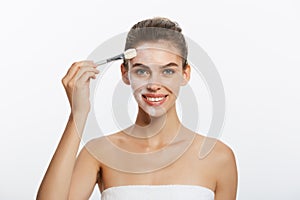 Portrait beautiful naked woman apply cosmetic white clay mask on with brush. Isolated on a white background. concept of