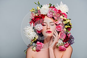 portrait of beautiful naked woman with closed eyes posing in floral wreath