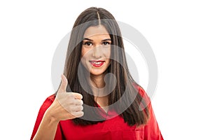 Portrait of beautiful nurse wearing red scrubs showing thumb up