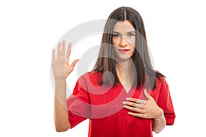 Portrait of beautiful nurse wearing red scrubs taking oath photo