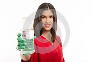 Portrait of beautiful nurse wearing scrubs drinking water