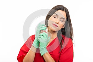 Portrait of beautiful nurse wearing scrubs putting on gloves