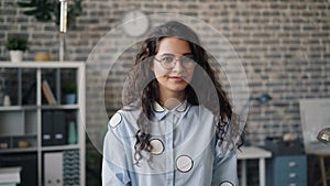 Portrait of beautiful office worker with long hair smiling and looking at camera