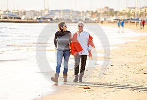 Portrait of beautiful older mom and mature daughter walking on t