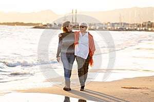 Portrait of beautiful older mom and mature daughter walking on t