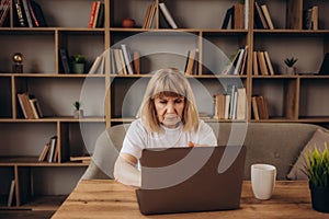 Portrait of beautiful older woman working laptop computer indoors