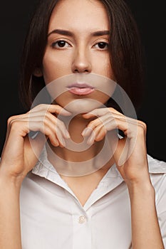 Portrait of a beautiful pacified woman in a white shirt on a light background