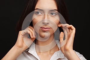 Portrait of a beautiful pacified woman in a white shirt on a light background