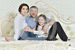 Portrait of a beautiful parents and daughter posing in room photo