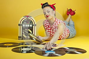 Portrait beautiful pin up listening to music on an old jukebox r