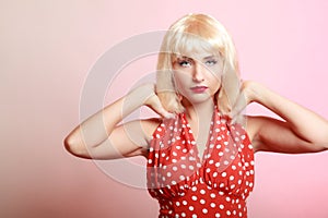 Portrait beautiful pinup girl in blond wig retro red dress. Vintage.