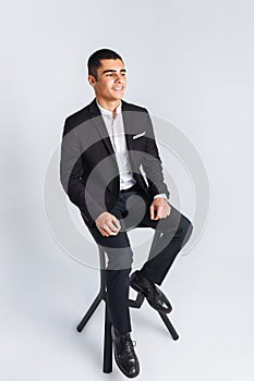 Portrait of the beautiful posing in a Studio, White background, Stylish business man, Stylish man sitting on a designer chair