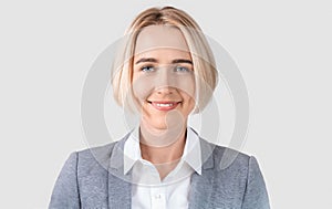Portrait of beautiful positive busness lady in formal wear on light grey studio background