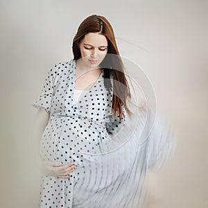 portrait of a beautiful pregnant young woman with long dark hair