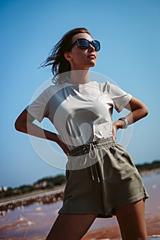 Portrait of a beautiful, pretty young woman with loose brown hair in sunglasses. Countryside landscape, nature. Freedom