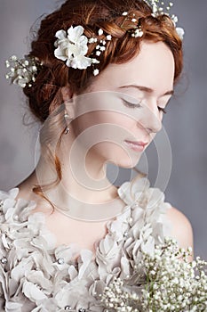 Portrait of beautiful red-haired bride. She has a perfect pale skin and delicate blush.