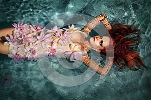 Portrait of red-haired girl in the water