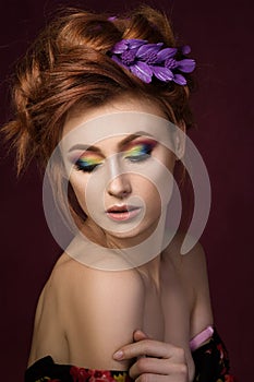 Portrait of beautiful redhaired woman with colourful creative ma